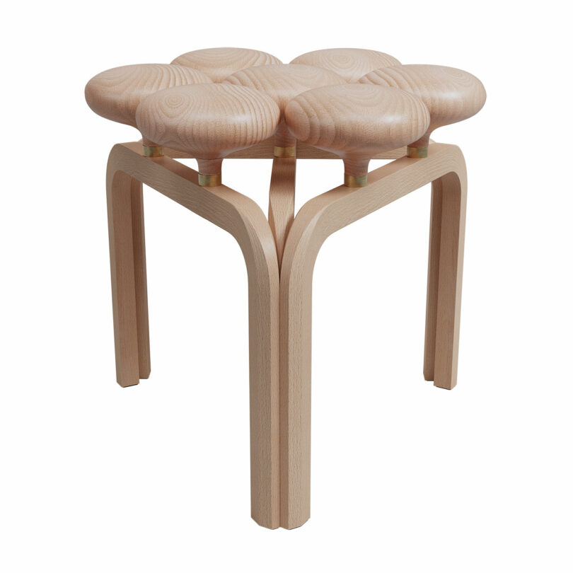 An Utzon Stool with a unique design featuring multiple rounded seat sections and four curved legs.