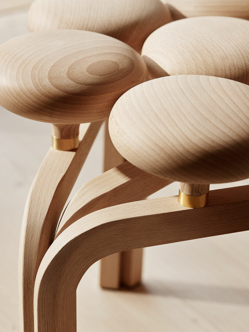 Close-up view of a modern, Utzon Stool with round, smooth seats and sleek, curved legs.