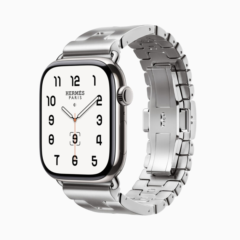 Silver smartwatch with a metallic strap, displaying a white watch face with black numerals and "Hermès Paris" branding.