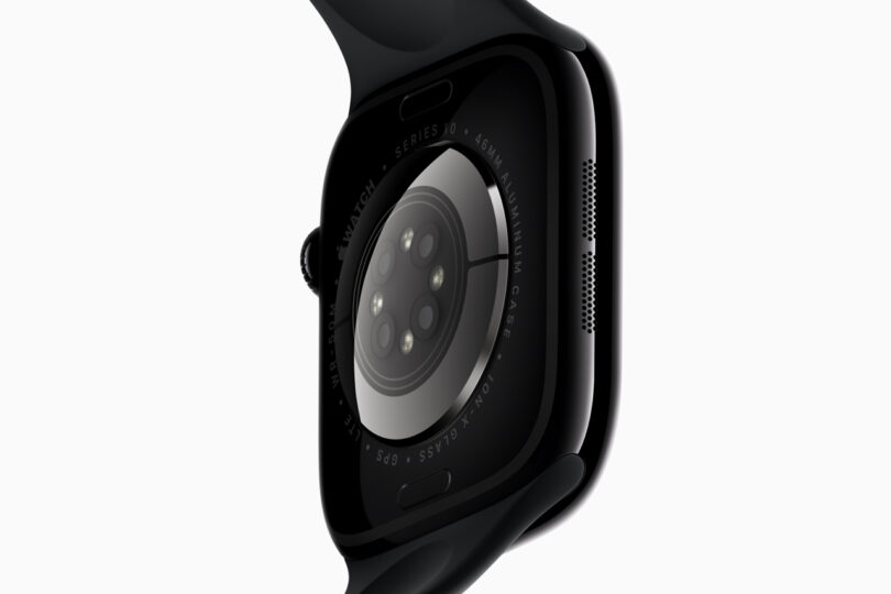 Close-up of the back of a black smartwatch showing its sensor array and curved design.