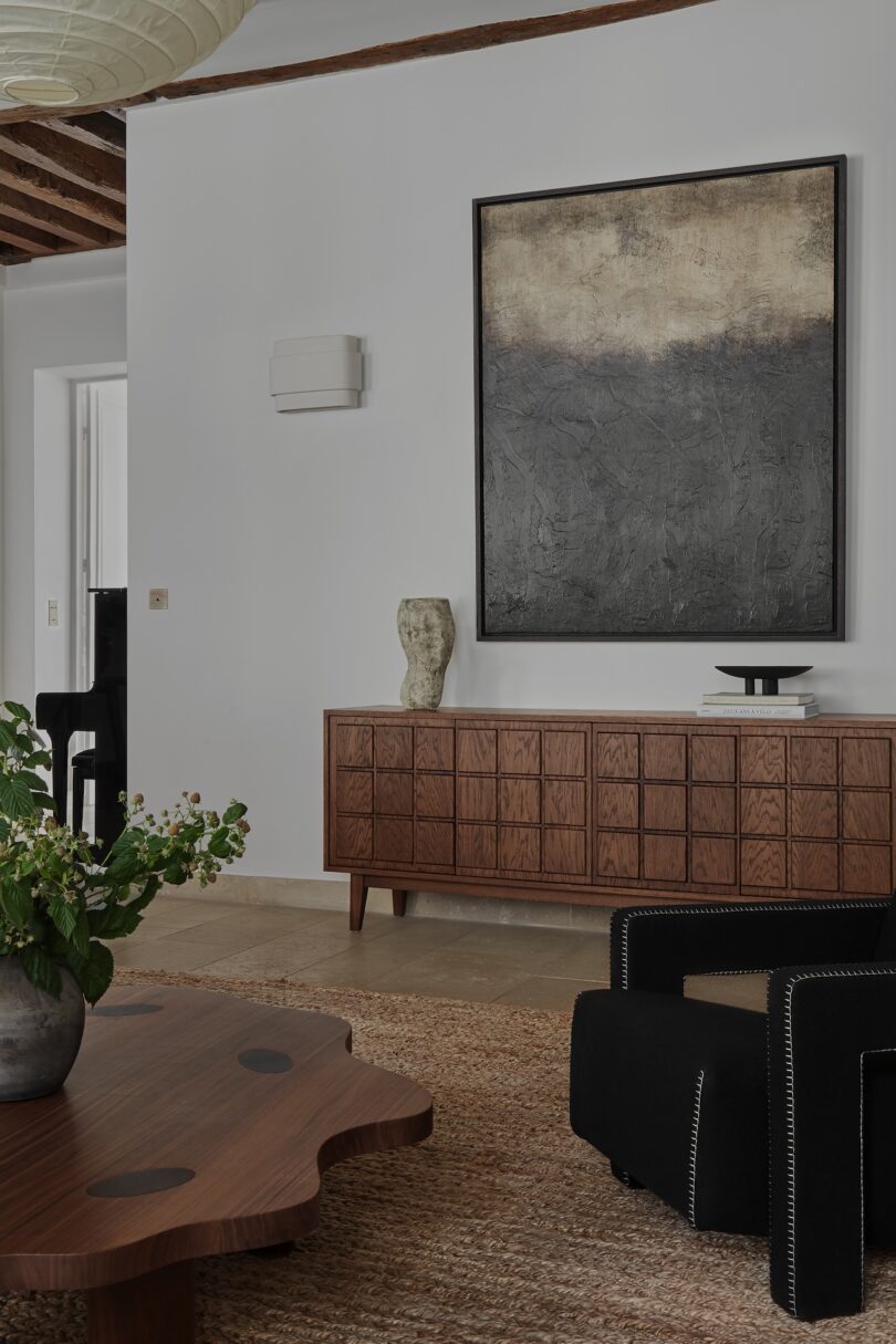 A detailed view of the living room, featuring a custom sideboard and abstract art