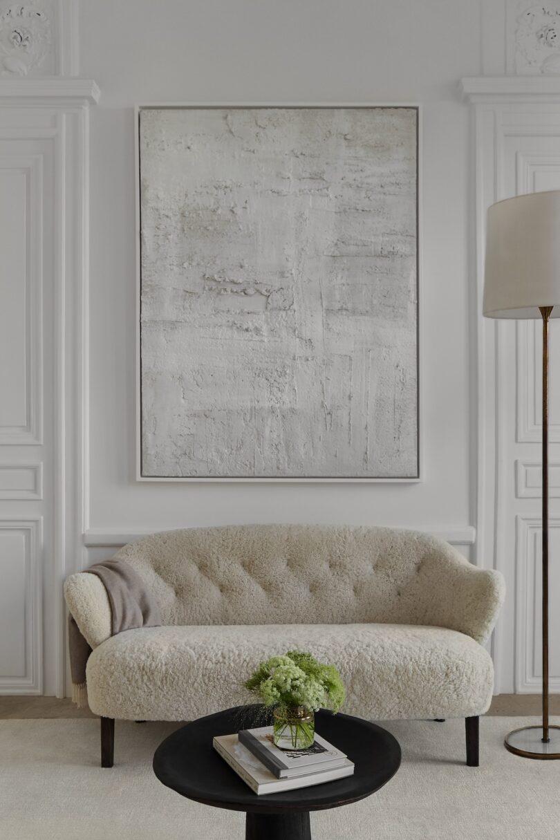 A cozy nook with a plush linen sofa, framed by white-washed walls and contemporary artwork