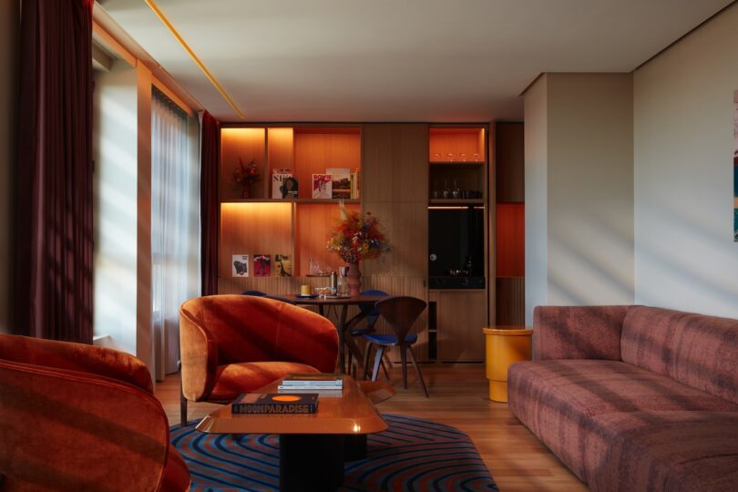 A spacious suite at SO/Paris featuring mid-century-inspired furniture, rich textures, and subdued lighting