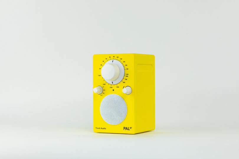 A yellow tabletop radio with dials for tuning and volume control, a circular speaker grill, and a rectangular shape, labeled "Tivoli Audio PAL+.