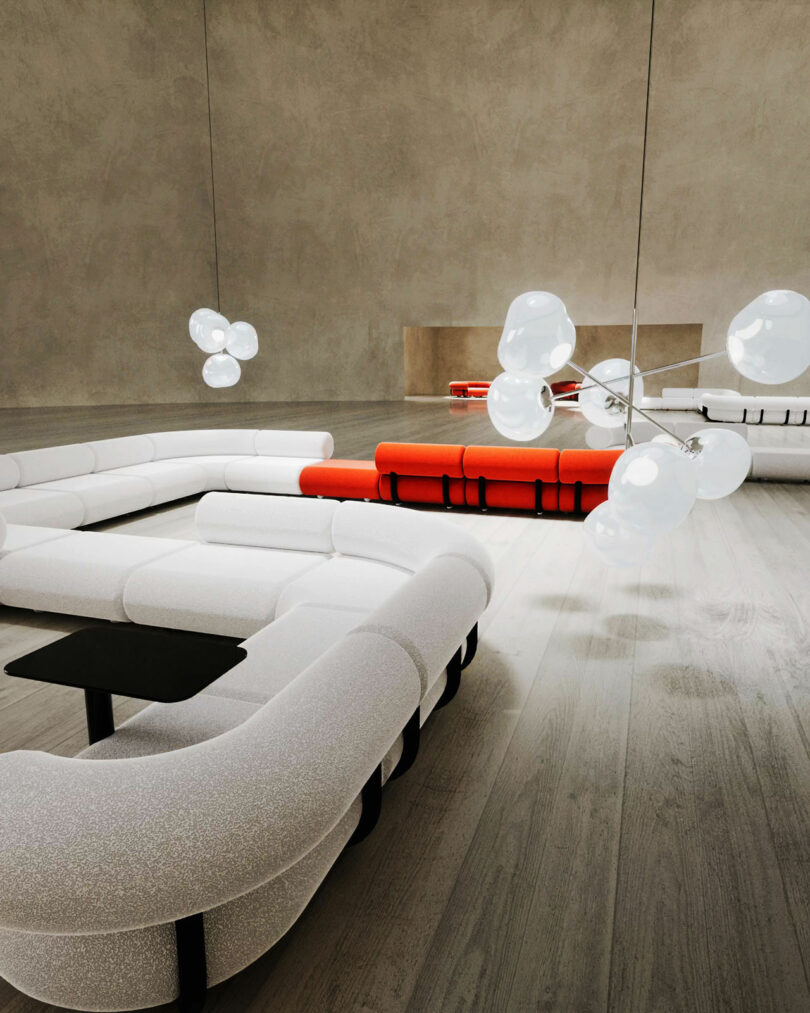 Minimalist interior with modern, white curved sofas and black side tables. Red sofa is in the background. Unique hanging light fixtures with bubble-like glass designs. Neutral-toned walls and flooring