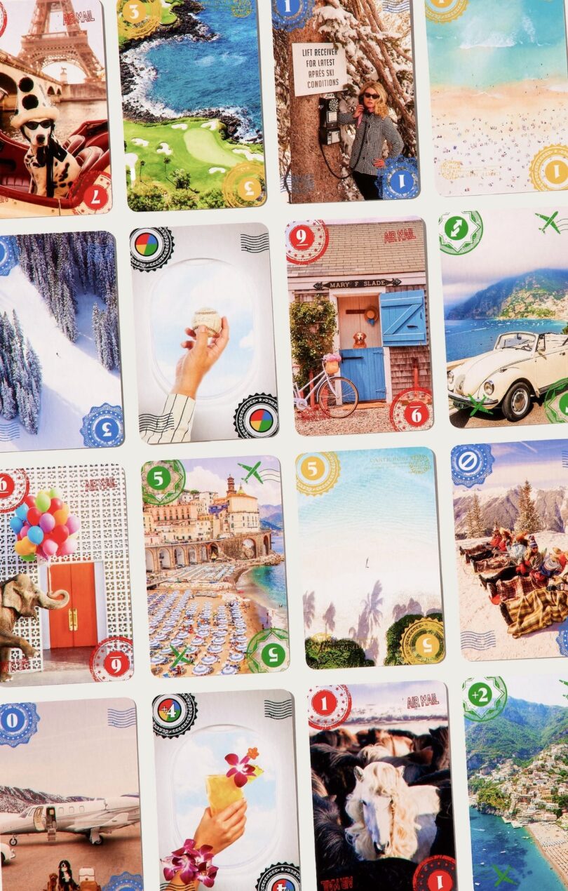 A grid of assorted travel-themed playing cards, depicting various picturesque locations, activities, and objects, including Eiffel Tower, ocean views, snowy mountains, and a vintage car.