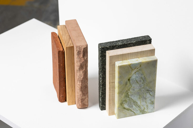 A selection of rectangular material samples, including stone, wood, and brick textures, displayed on a white surface.