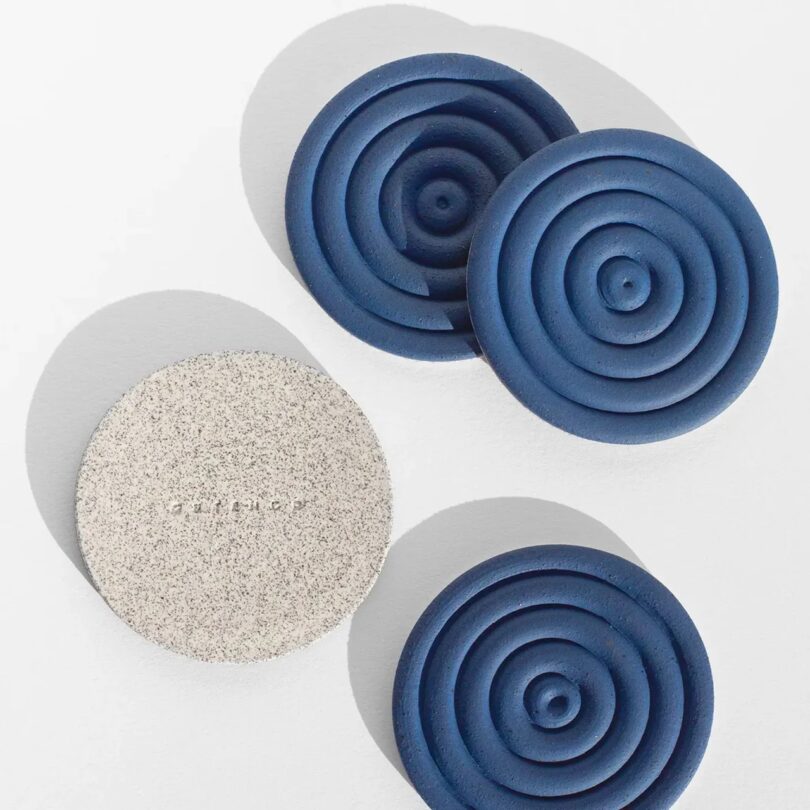 three blue spiral coasters and one flipped over showing it's speckled underside