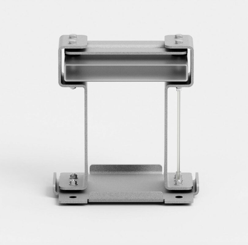 Metallic bracket with two vertical supports and a horizontal bar at the top, featuring bolts for assembly on a flat base, placed against a plain background.