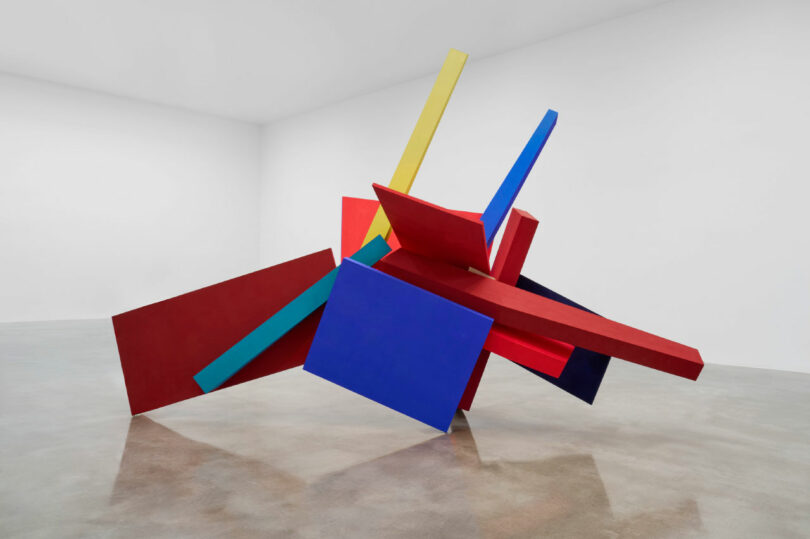 Large wood sculpture in red, blue and yellow.