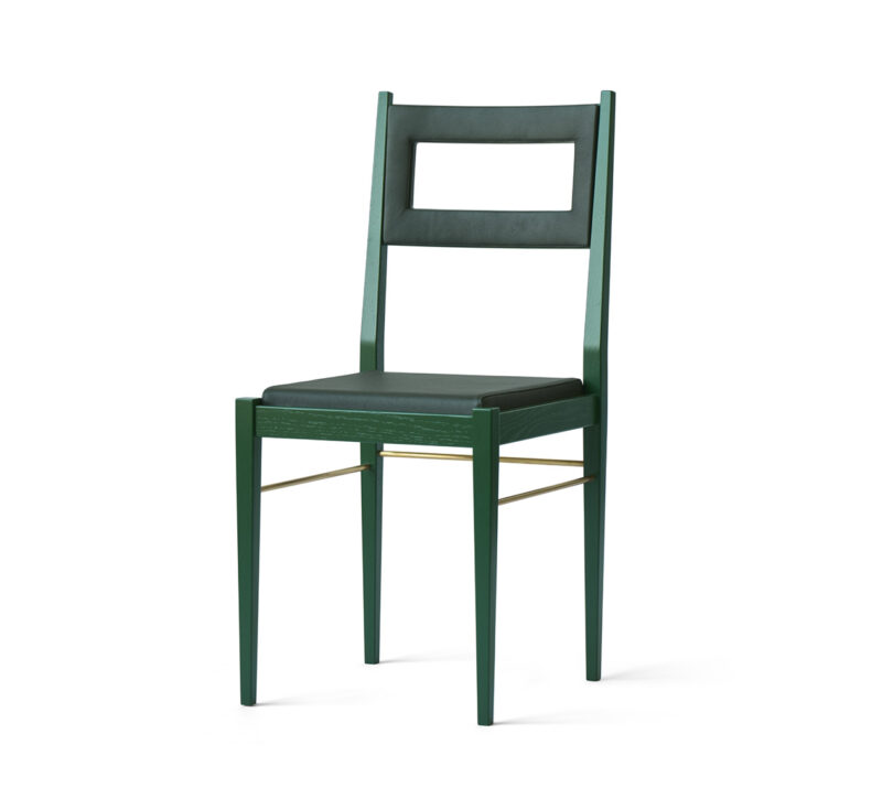 A modern green chair with a rectangular cutout in the backrest and thin metal support bars connecting the legs.