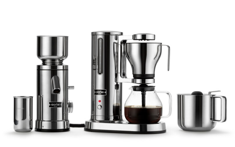 Discover the Aarke Coffee System, a sleek stainless steel coffee-making set complete with a grinder, water kettle, drip coffee maker for perfectly brewed coffee, and a milk frother.