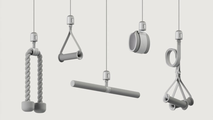 Five different gym cable attachments hanging vertically against a plain background, including ropes, handles, and bars.