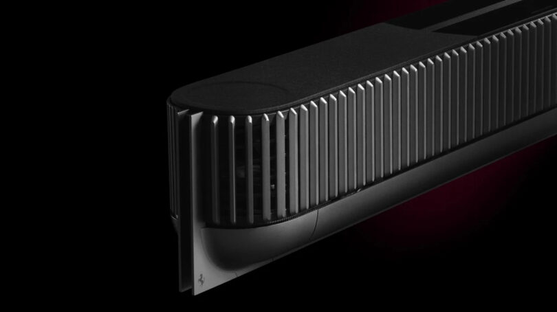 A sleek, black, ribbed electronic device with a rectangular shape against a dark background.