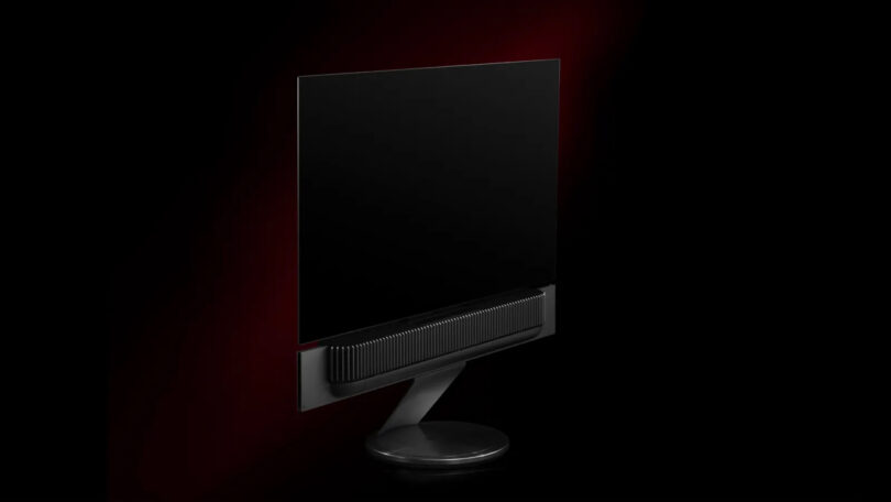 A sleek, black flat-screen monitor with a minimalist design against a dark red background.