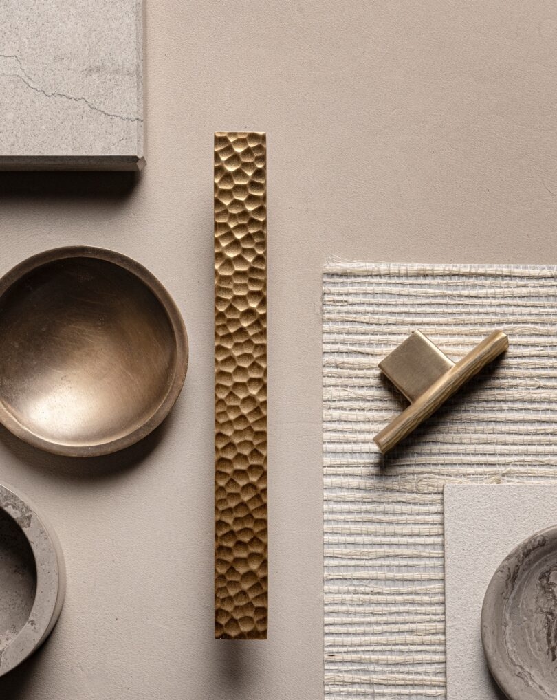 A collection of textured bronze hardware on a neutral-toned surface,