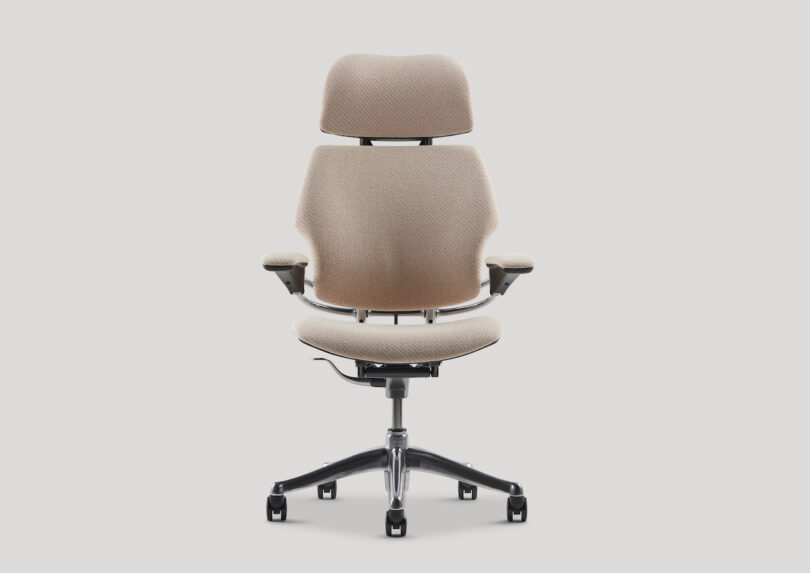 Ergonomic office chair with beige upholstery, adjustable headrest, armrests, and a five-wheel black base