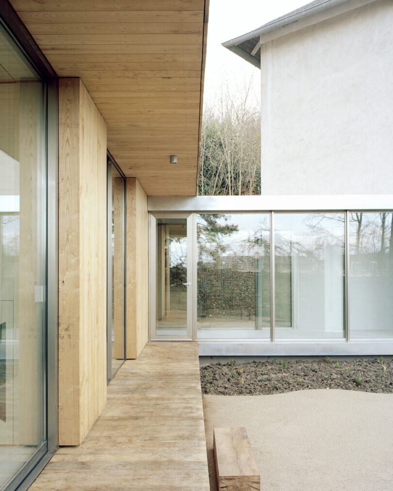 Modern architecture with wooden and glass elements, featuring large windows and a minimalist design.