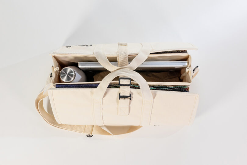 Top view of an open BASK Bag from two-point, revealing a laptop, a stainless steel water bottle, and folded clothes neatly tucked inside.