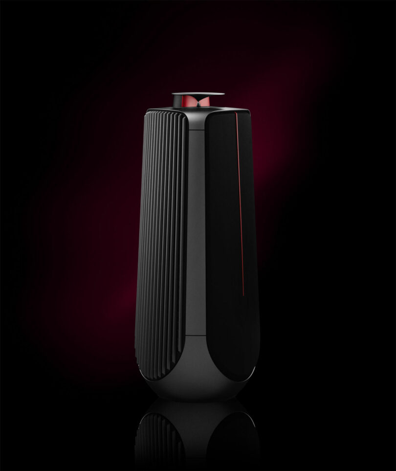 Sleek black and red speaker with a vertical ribbed design, reminiscent of a Ferrari's elegance, set against a dark gradient background.