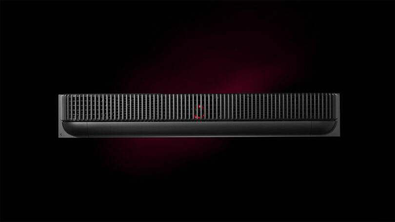 Front view of a sleek black electronic device with a vent-like design, reminiscent of a Ferrari's aerodynamic lines, set against a dark background.