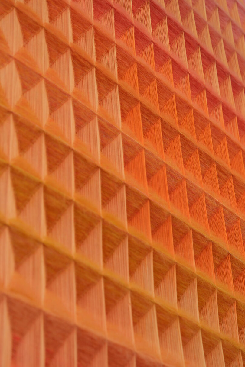 Close-up of an orange and yellow pyramid-shaped 3D texture pattern, reminiscent of Anya Molyviatis' signature style.