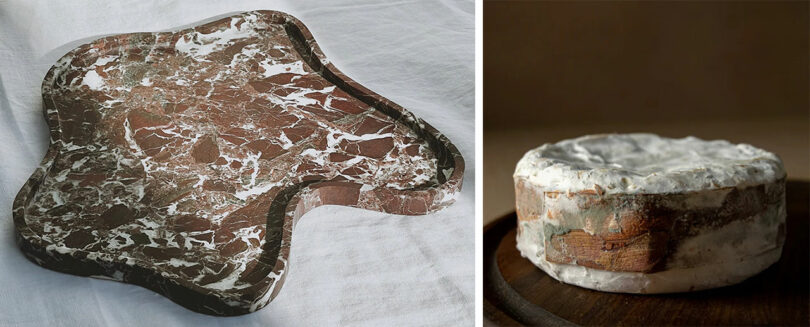 A uniquely shaped, marbled tray beside a round, rustic cheese wheel on a dark wooden surface.