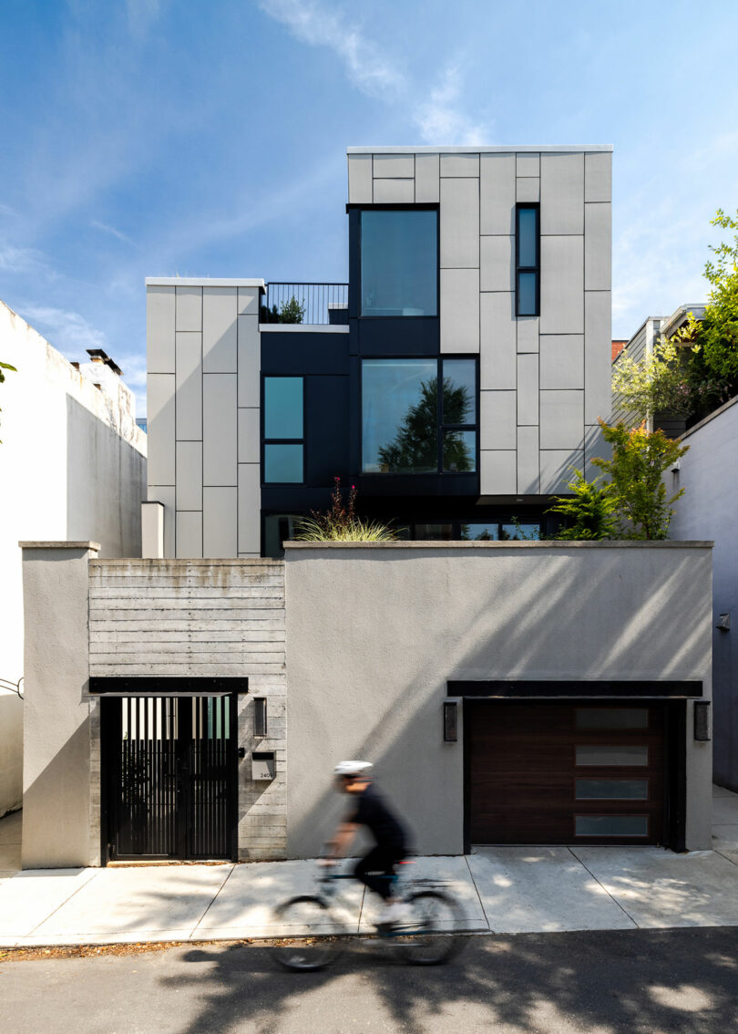 The modern multi-story building, a testament to Gnome Architecture, boasts large glass windows and a minimalistic design as a cyclist glides by in the foreground.