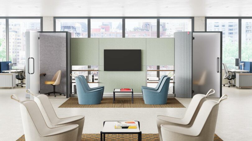 Modern office lounge with a central TV, four armchairs, two enclosed booths, and floor-to-ceiling windows. Neutral tones with blue and beige furniture.