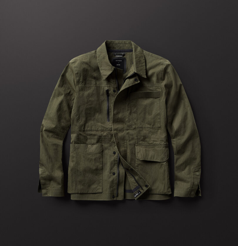 Olive green utility jacket with multiple pockets and a front zipper, displayed on a dark background.