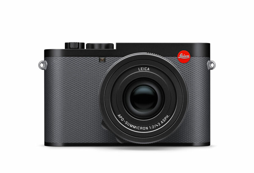 The gray Leica Q3 43 camera features a prominent lens and textured grip, proudly displaying the iconic Leica logo in red.