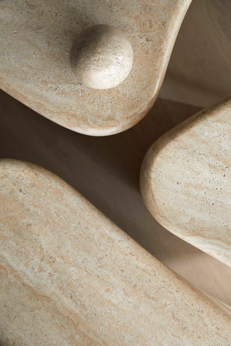 Abstract arrangement of smooth, beige stone shapes with rounded edges, including a sphere on top