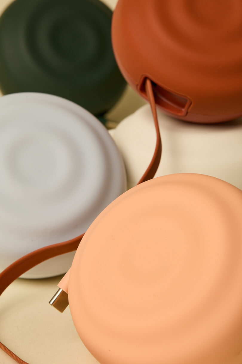 A collection of circular, flat objects in muted colors with strap handles.