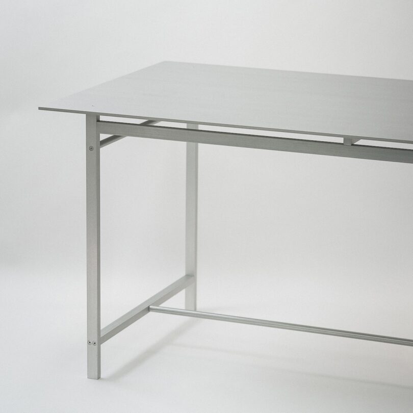 Metal table with a minimalist design set against a plain background.