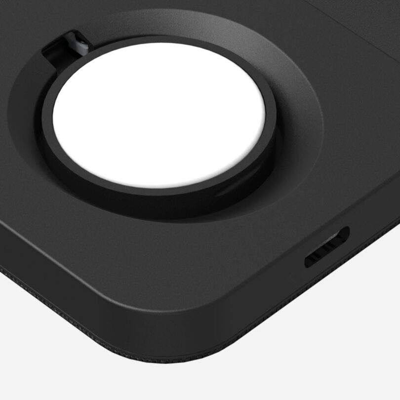 Close-up of a black charging pad with a circular white charging surface and a USB-C port on the side.