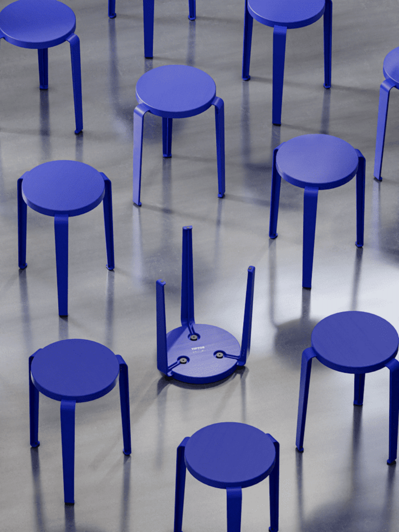 Several blue stools on a reflective floor, with one stool turned upside down