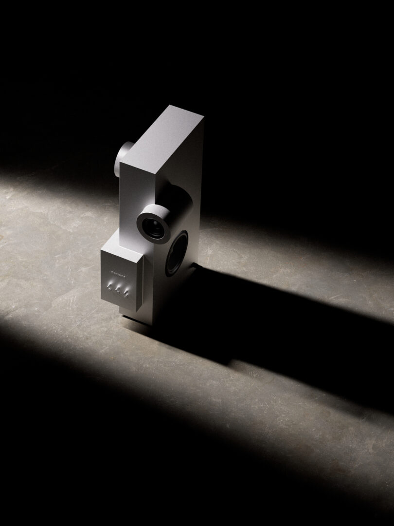 A minimalist, geometric sculpture on a concrete surface, lit dramatically, casting a long shadow.