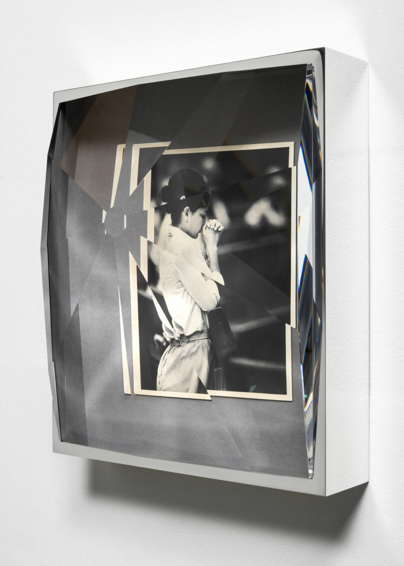 Photograph of woman with hands clasped within prismatic frame at an angle