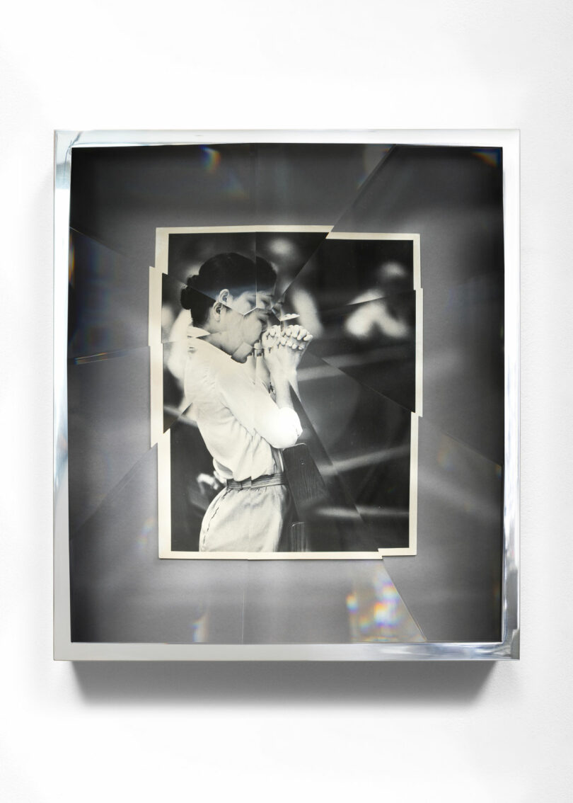 Photograph of woman with hands clasped within prismatic frame