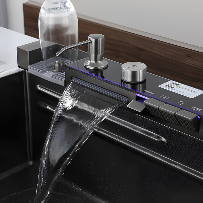 Modern faucet with a digital panel and square spout, dispensing water into a sink. A soap dispenser and a bottle are on the countertop.