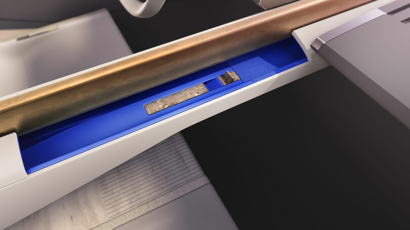 Cross-section view of an escalator with a focus on the machinery inside, including gears and a blue compartment.