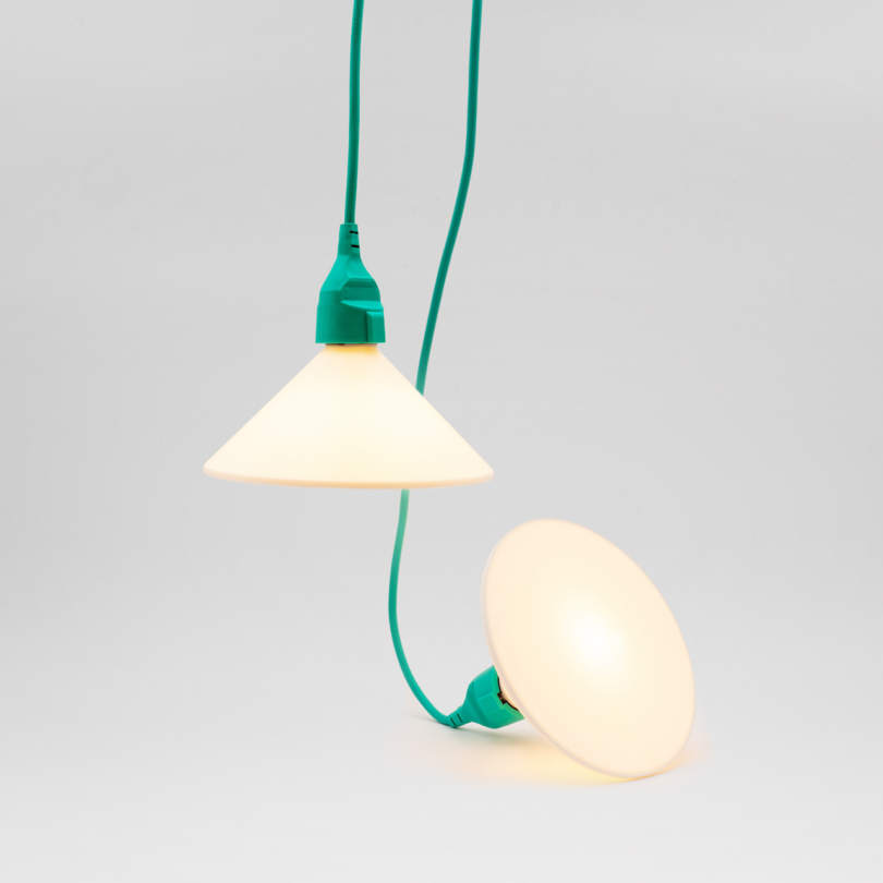 Two cone-shaped pendant lights with green cords are hanging against a white background