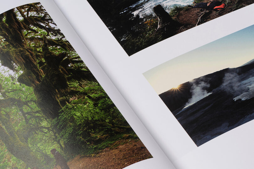 A book open to pages with photographs of a lush green forest and a volcanic landscape with steam and sunlight.