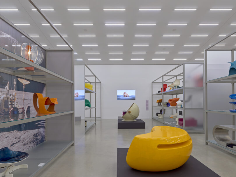 A modern exhibit showcasing colorful abstract furniture displayed on shelves under bright ceiling lights.