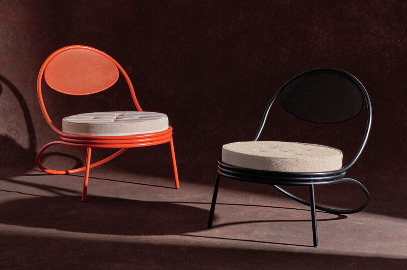 Two modern chairs with circular backs and beige cushions, one red and one black, on a dark brown background.