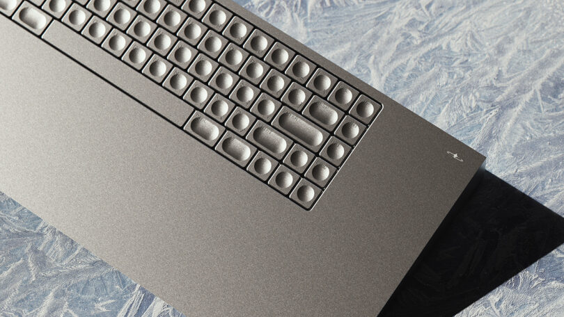 Un clavier minimaliste avec des touches arrondies sur une surface bleue texturée.