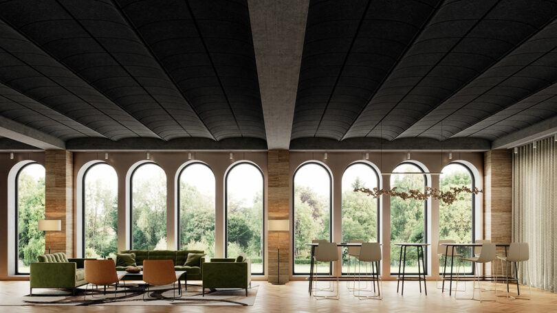 A modern lounge area with arched windows, green and tan seating, a high table with chairs, and a view of trees outside.