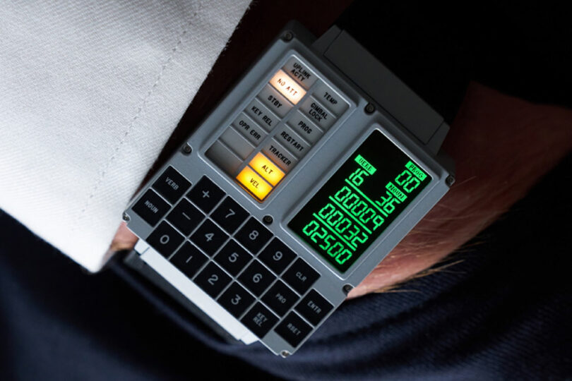 A retro-style digital wristwatch with a calculator and various buttons, including an illuminated "ML" button, is shown close-up on a wrist.