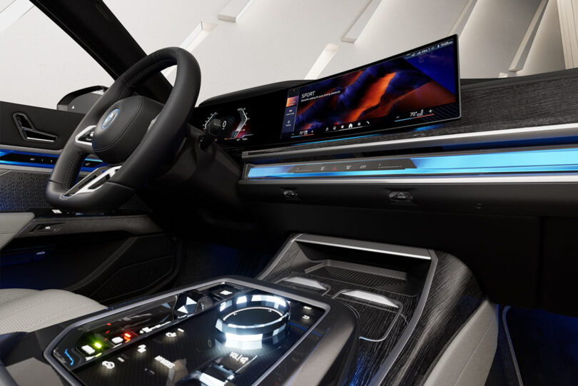 Futuristic car interior with a digital dashboard, large touchscreen displays, sleek steering wheel, and ambient lighting.