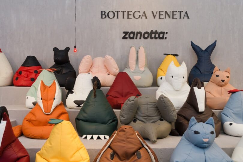 Collection of animal-shaped bean bag chairs in various colors displayed on steps below "Bottega Veneta" and "Zanotta" signage